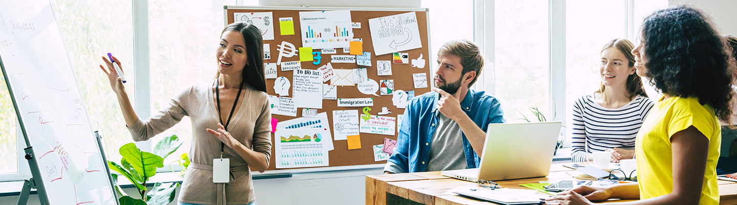 Employees brainstorming ideas on a whiteboard.