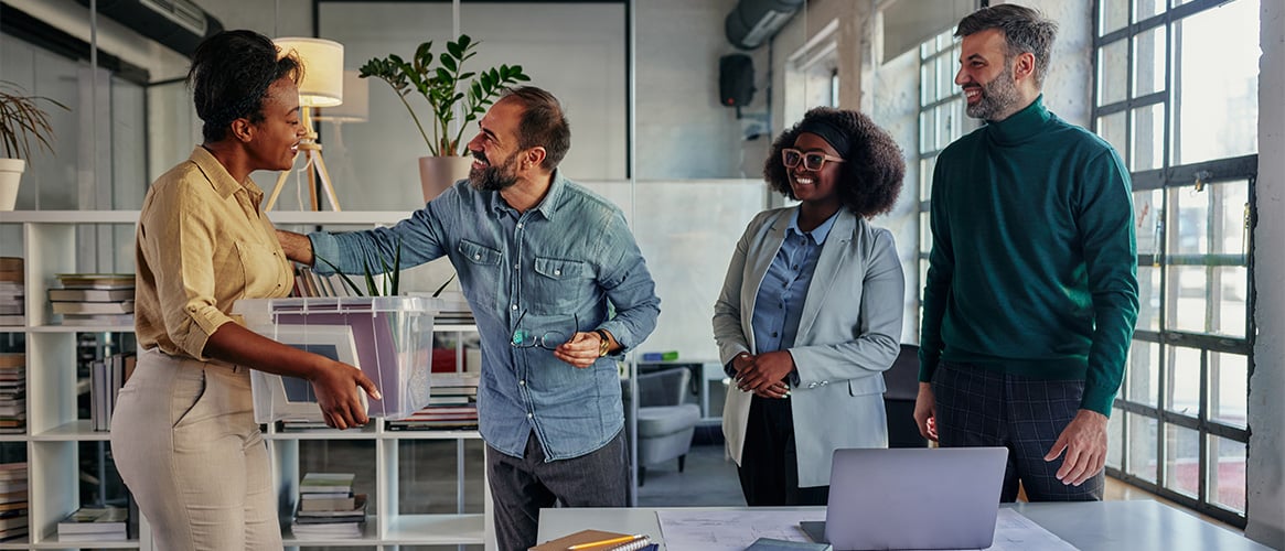 Woman returns to work and is greeted by her colleagues.