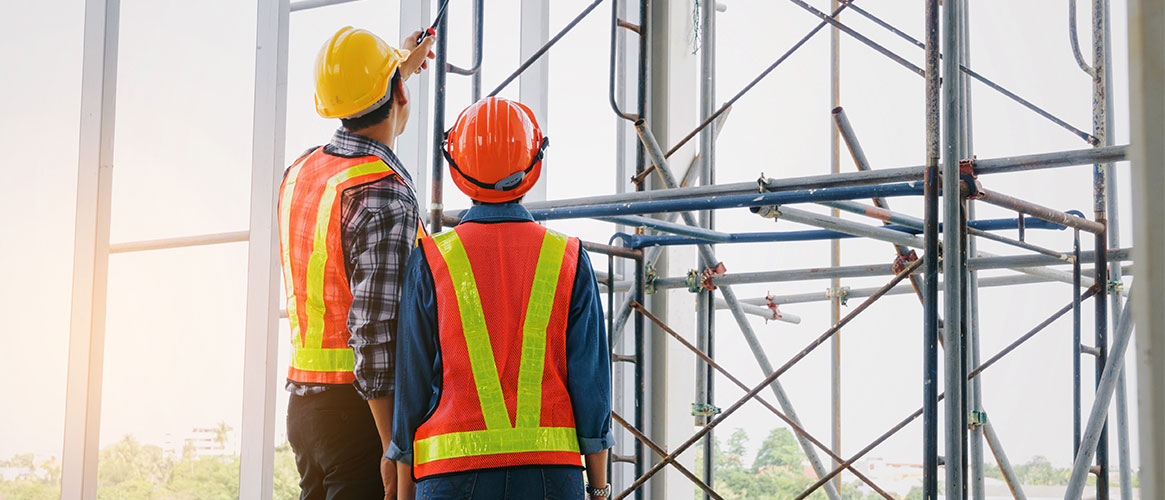 Construction workers inspecting scaffolding system