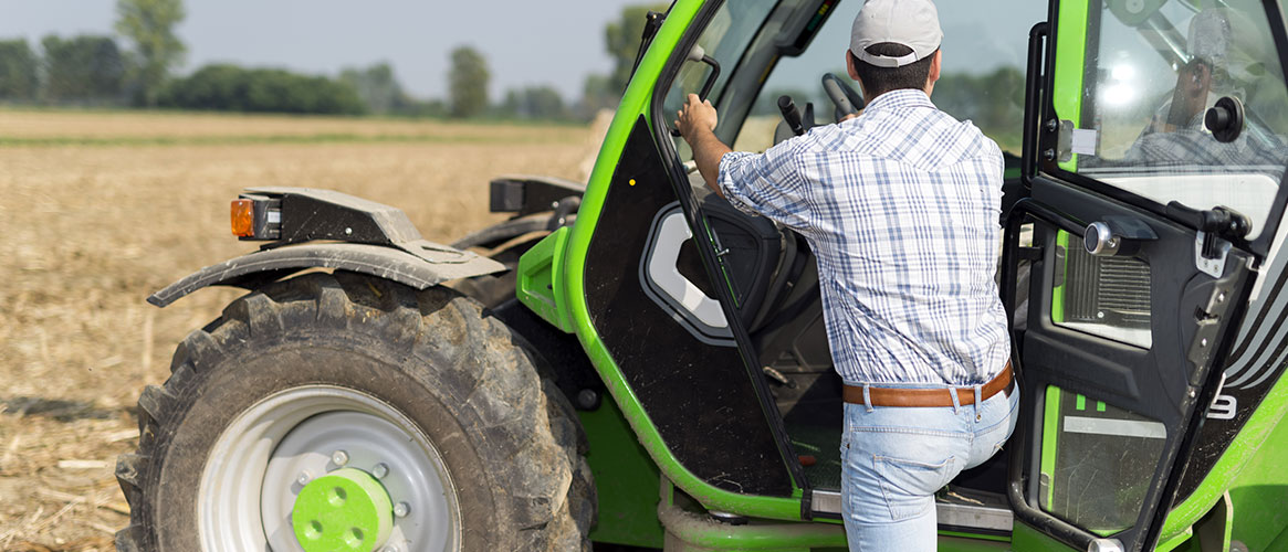 worker getting into a tractor